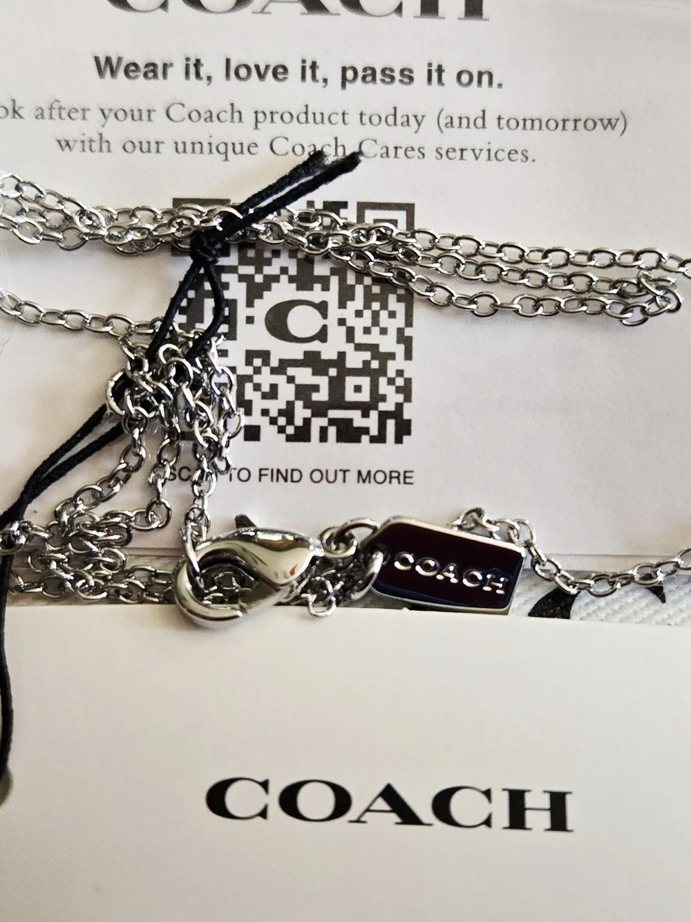 Coach silver-tone necklace features a small, heart pendant with COACH tag